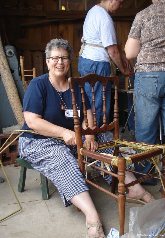 Cathryn Peters demonstrating weaving a hand-twisted cattail chair seat