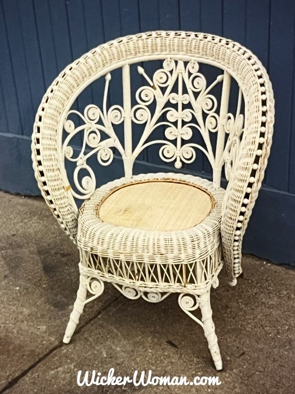 White painted Victorian Heywood-Wakefield ladies chair heavily embellished with wooden beads along the swooping arm and back. Curlicues throughout the back and apron.