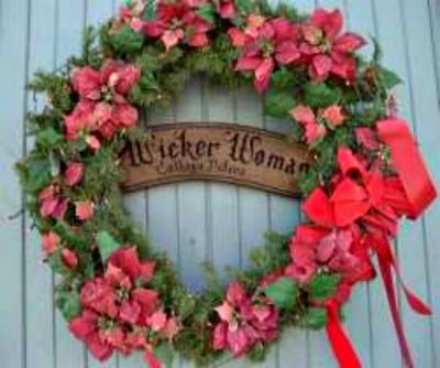 The Wicker Woman© Christmas Wreath with red bows and poinsettia flowers on wicker repair shop, Zumbro Falls, MN.