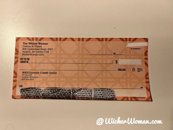 Free advertising by using business checks with orange-background-chair caning graphic. 