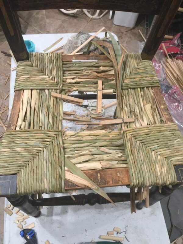 Hand-twisted cattail rush chair seat, midway in weaving process.